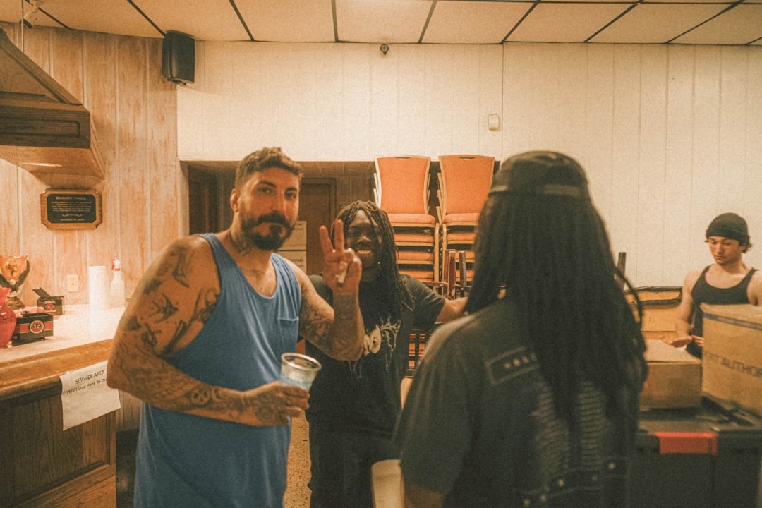 People gathered in a community hall with a man making a peace sign.